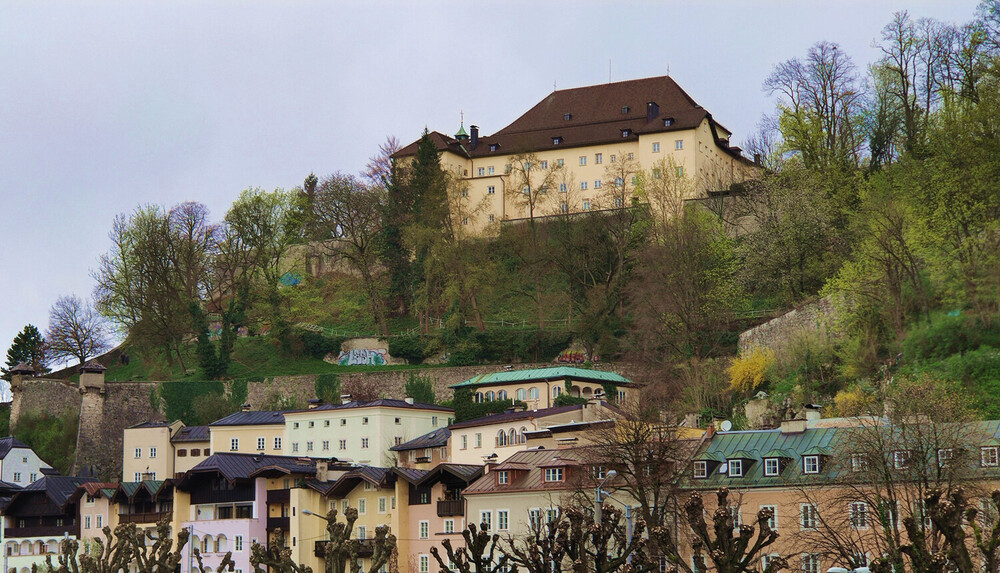 Blick auf das Kapuzinerkloster, das sich über den historischen Häusern der Steingasse am Kapuzinerberg erhebt.